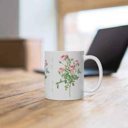 A chique powder pink rose Double Blush on a white porcelain cup that stands on a desk